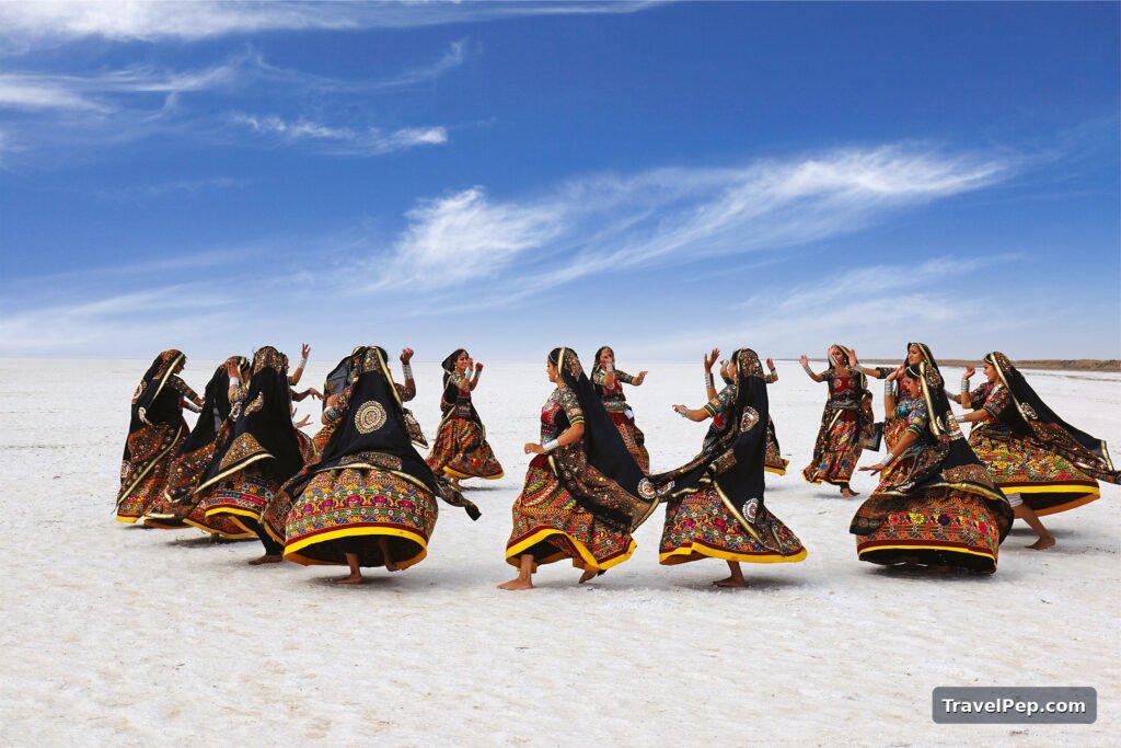 Rann Utsav 2026-27 at Dhordo: Dates, Tent City, Permit, and the Best Nights to Go 14 Dancers in Kutchi dress performing garba on the white salt flats